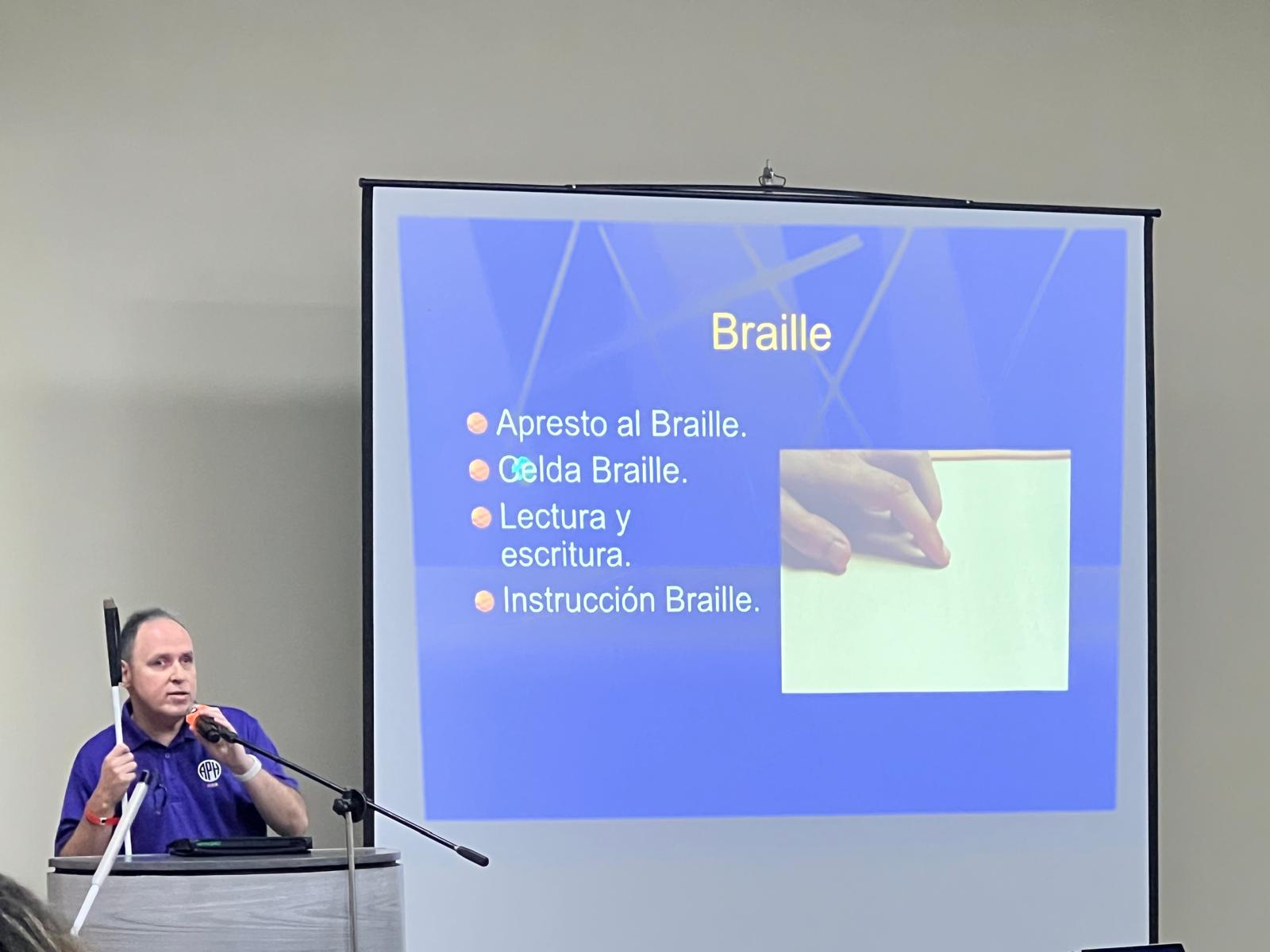 La foto presenta a Manolo en el podio durante su charla.